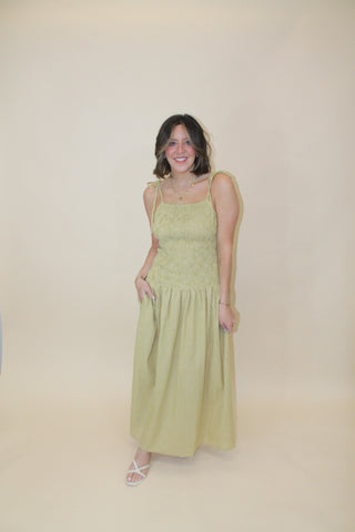Woman in a light green dress lying on a beige floor