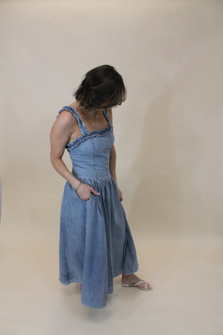 Woman wearing a blue dress against a plain background