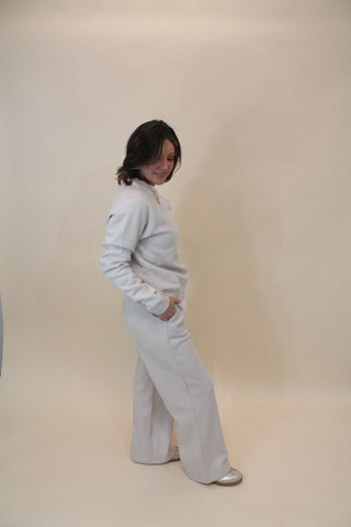 Person wearing a white outfit against a plain background