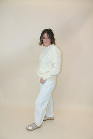 Person wearing a white outfit on a plain background