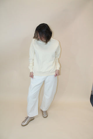 Person wearing a white outfit on a beige background