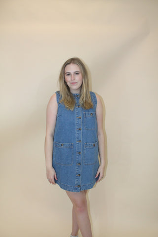Woman wearing a denim dress against a plain background