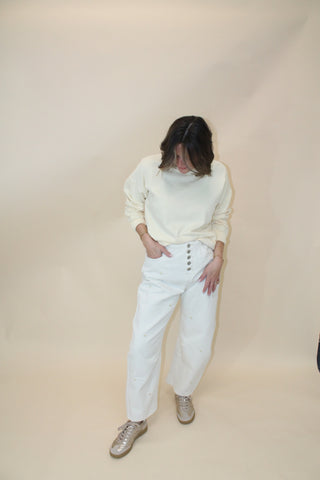 Person wearing a white outfit with a beige background