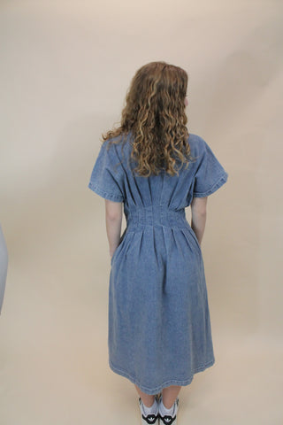 Denim dress worn by a person on a beige background