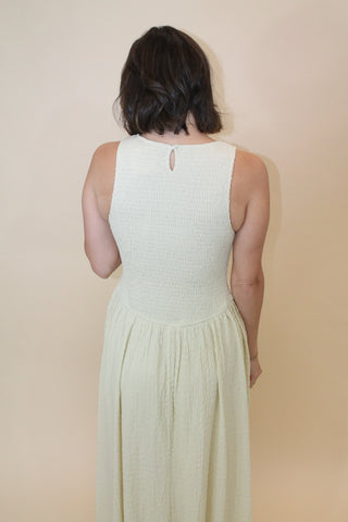 Person wearing a white dress lying on a beige surface