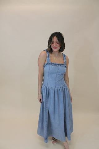 Woman wearing a light blue dress against a plain background